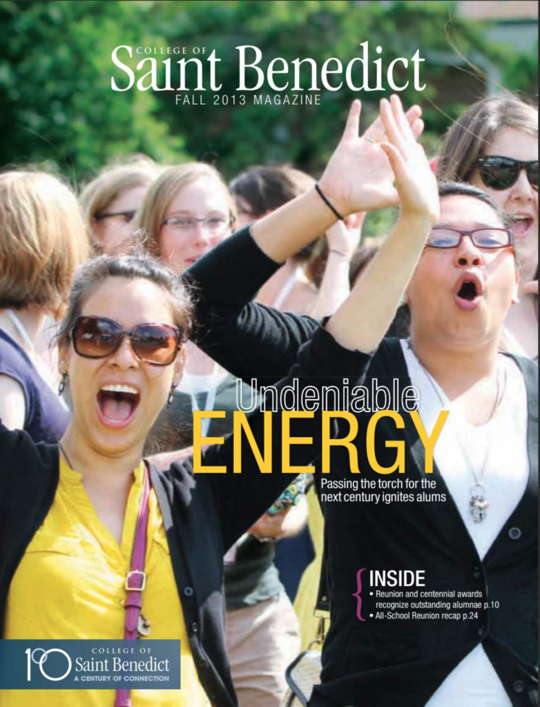 A group of excited people celebrates outdoors. A woman in the foreground wears sunglasses and has her mouth open, raising her arm in enthusiasm. The magazine cover reads "College of Saint Benedict Fall 2013 Magazine" with the headline "Undeniable Energy.